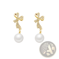 Gold crystal bow earrings with sparkling crystals and white pearl dangles in elegant gold setting