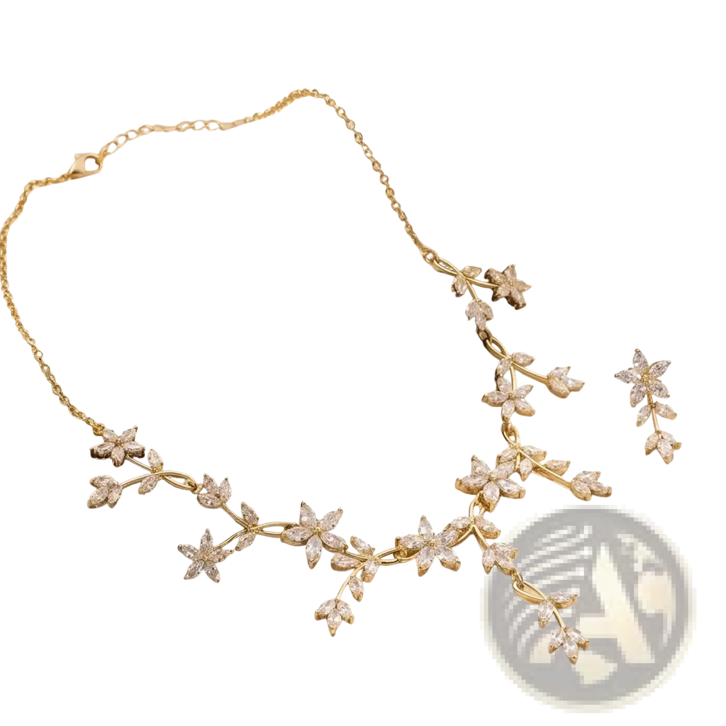 Crystal bridal necklace and earring set in gold tone with delicate floral and leaf motifs adorned with clear crystals