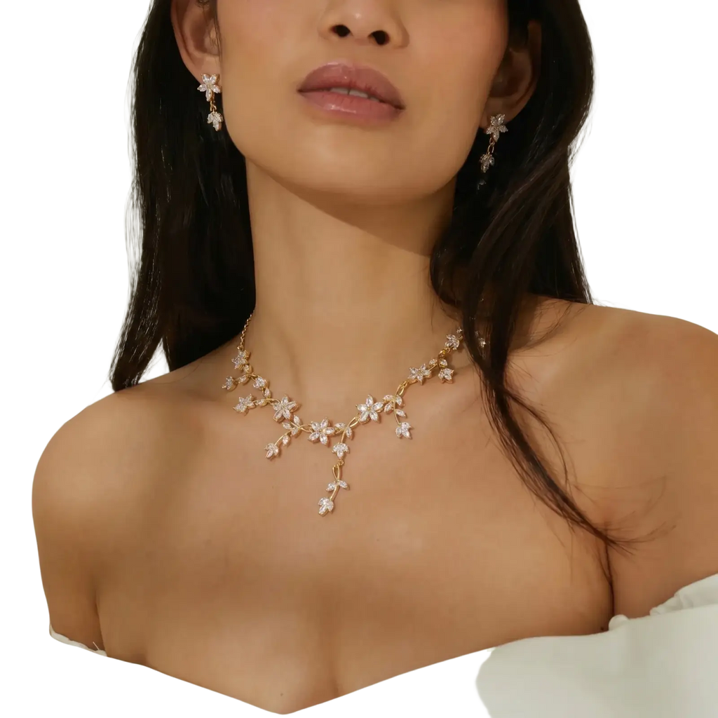 Gold-toned crystal bridal necklace featuring delicate floral designs with sparkling clear stones for weddings
