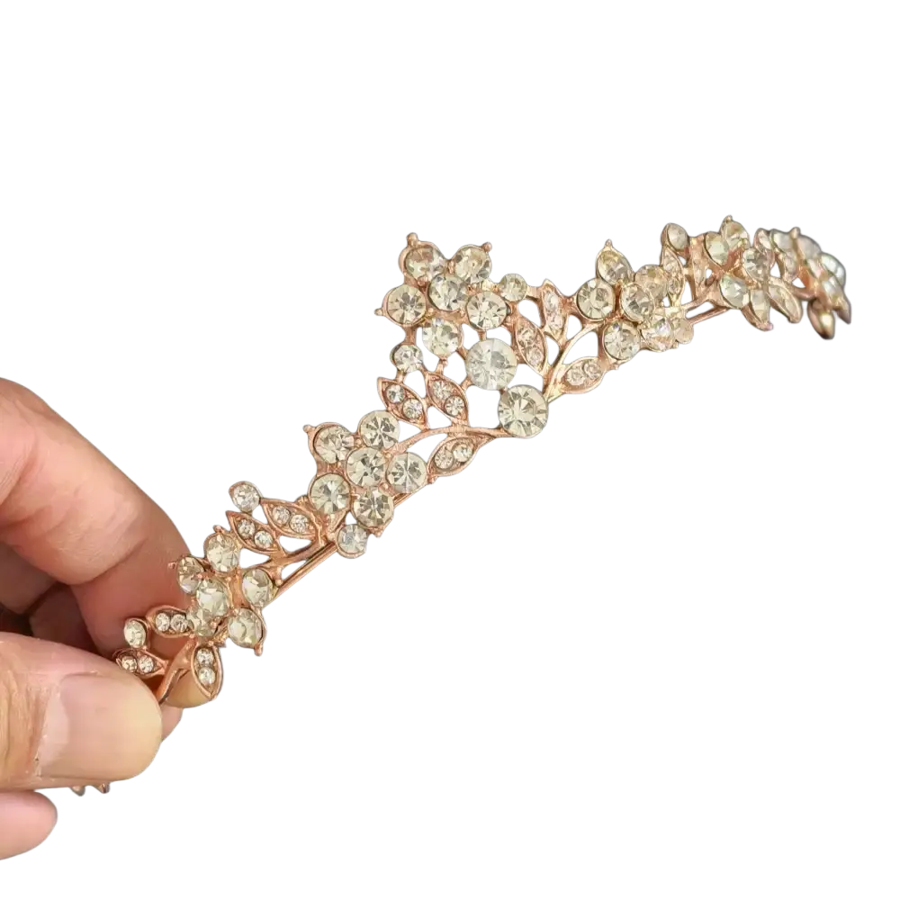 A delicate rose gold crystal bridal tiara with floral and leaf motifs perfect for weddings