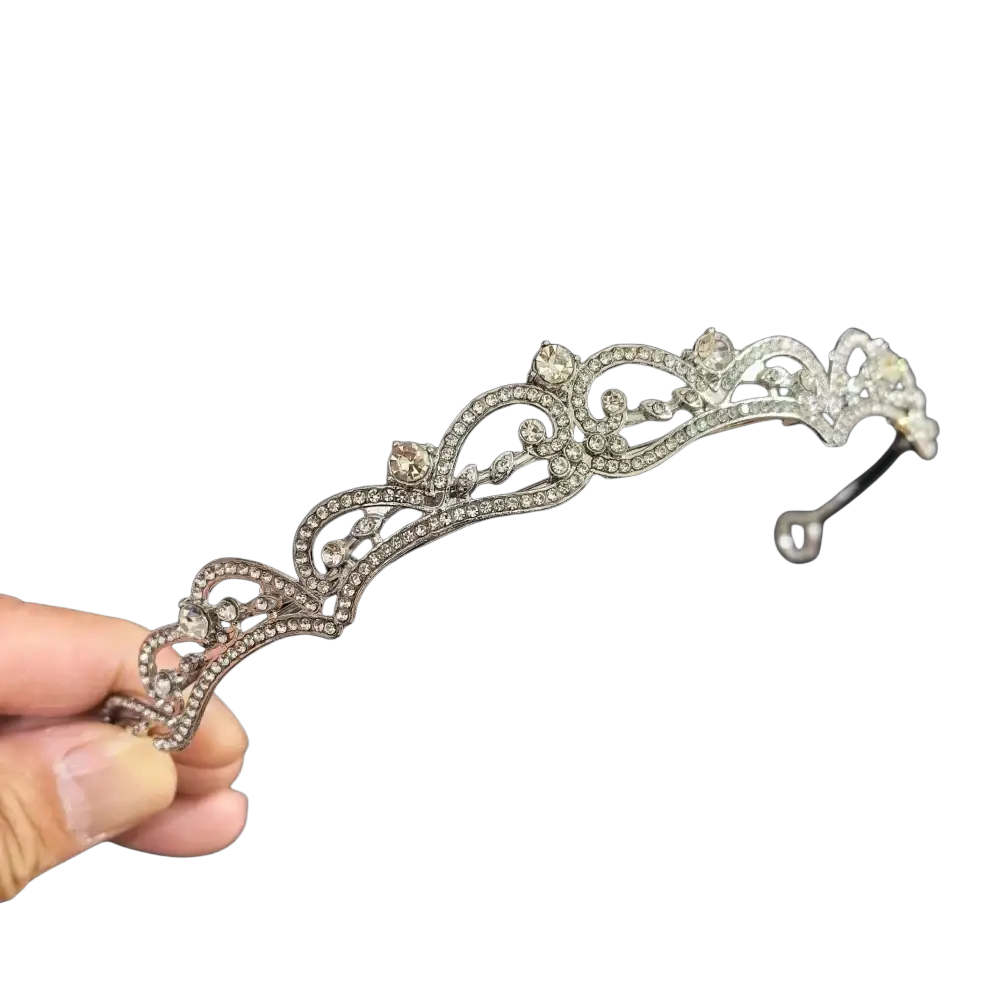 An elegant silver crystal bridal tiara with intricate filigree and sparkling clear crystals for wedding use