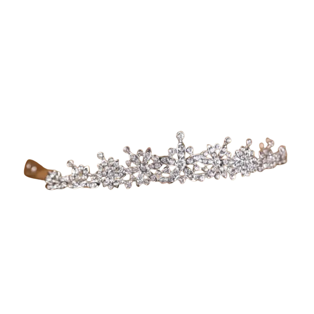 A sparkling silver crystal bridal tiara with intricate floral designs resting elegantly in a wooden crate