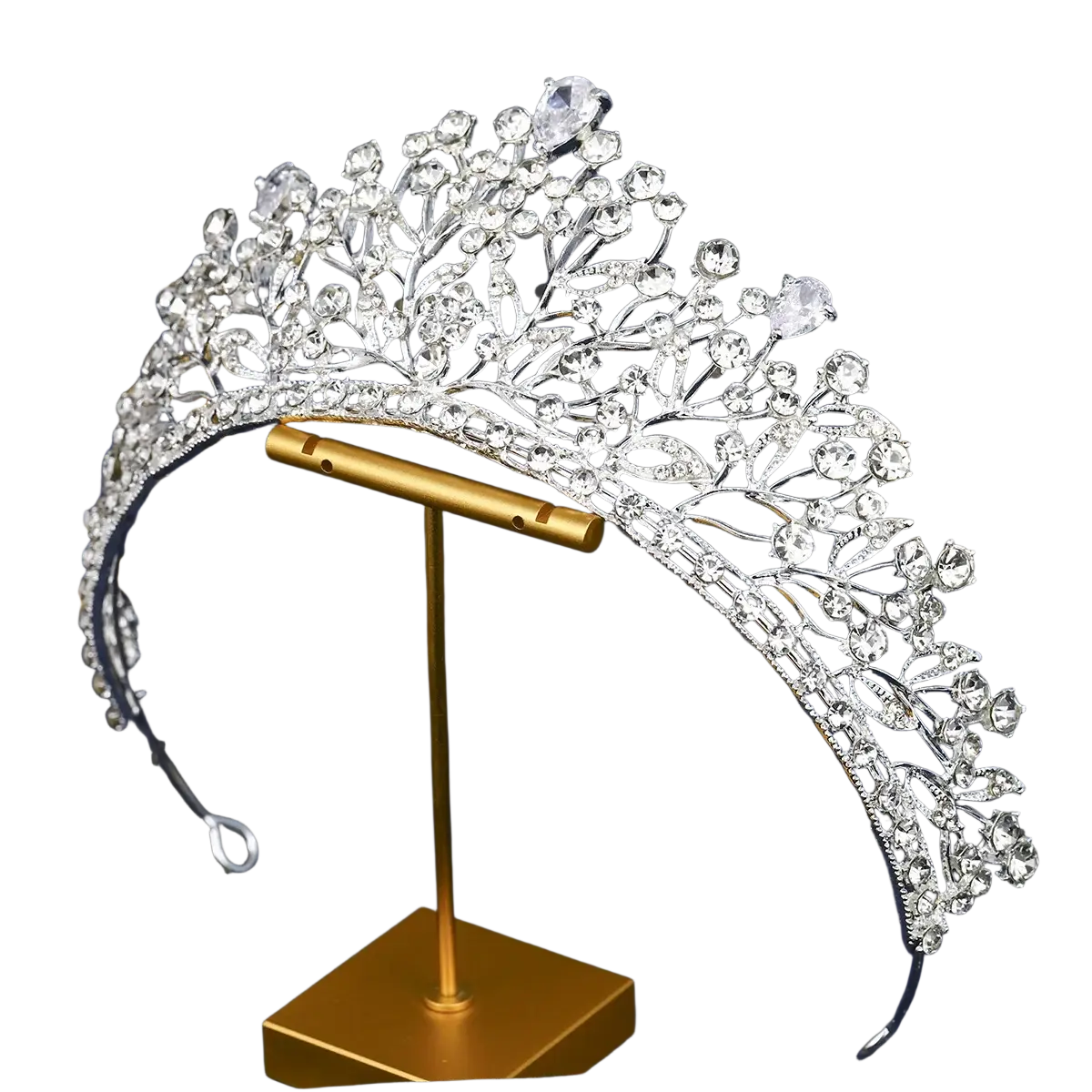 A sparkling silver crystal bridal tiara with intricate leaf-like metalwork displayed on a gold stand