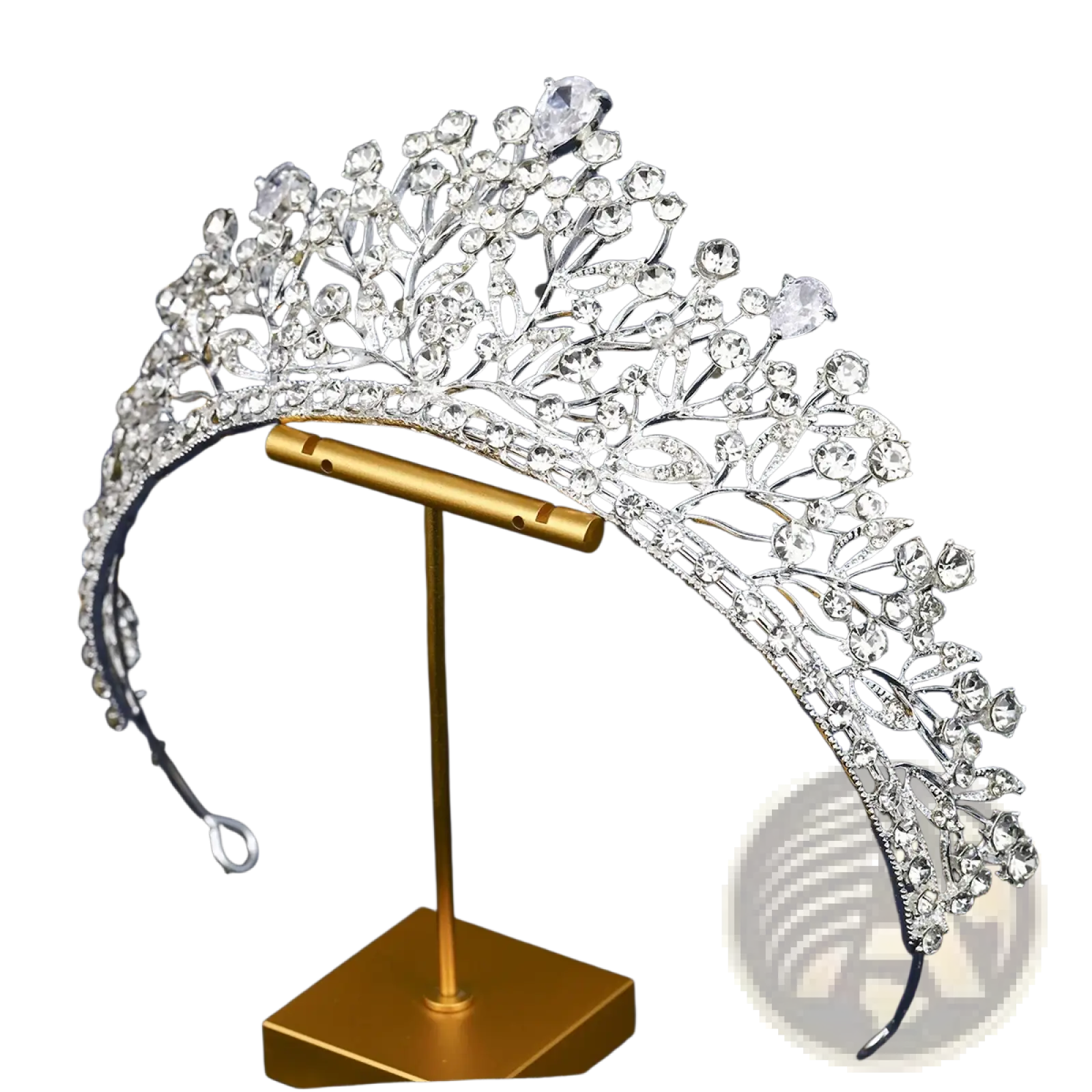 A sparkling silver crystal bridal tiara with intricate leaf-like metalwork displayed on a gold stand