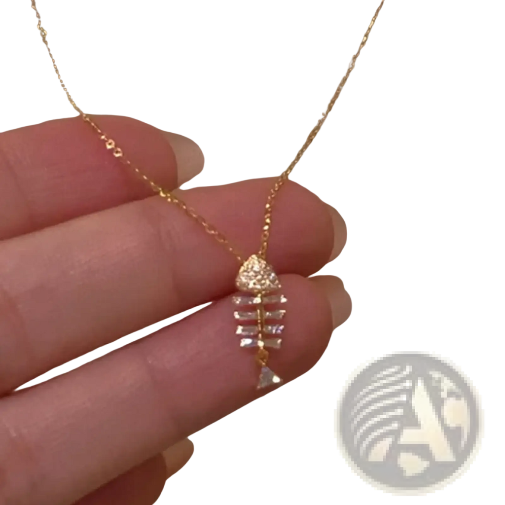 A delicate gold chain necklace with a fishbone-shaped pendant adorned with clear crystals