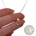 A delicate gold chain necklace with a fishbone-shaped pendant adorned with clear crystals