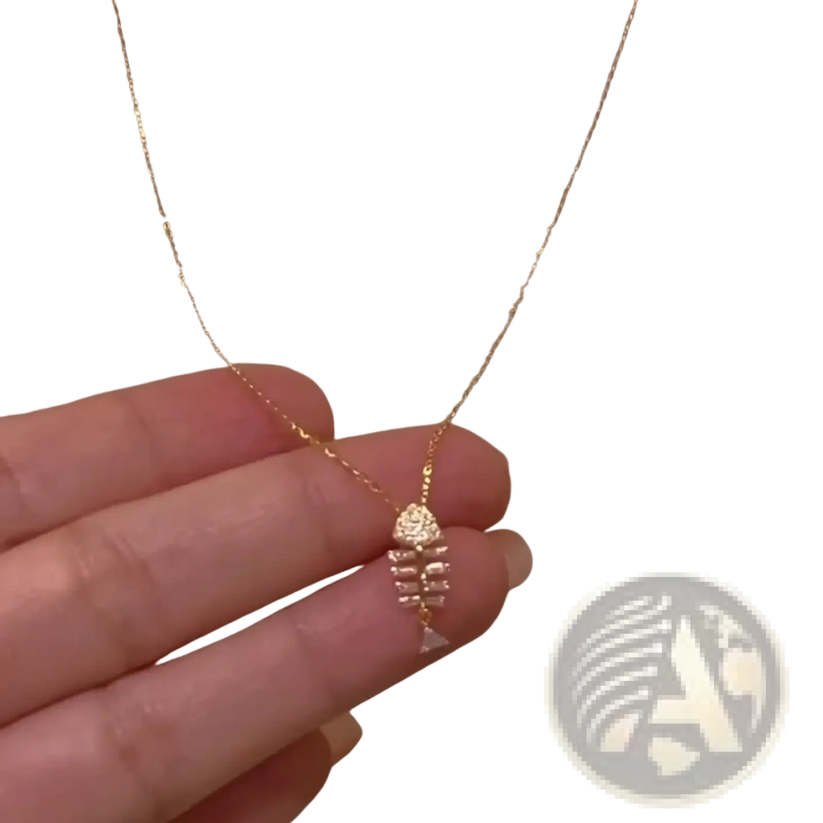 A delicate gold chain necklace with a small crystal-adorned fishbone pendant for elegant jewelry wear