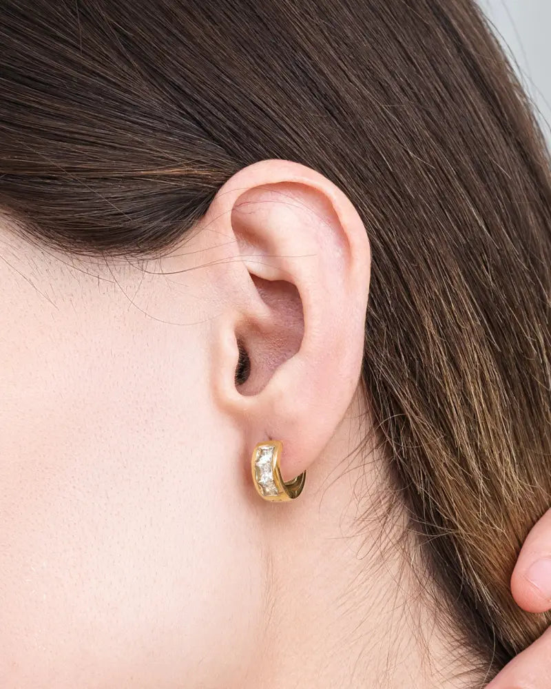 Gold magnetic crystal huggie earring in gold tone with clear sparkling stones and therapy magnets along curved edge