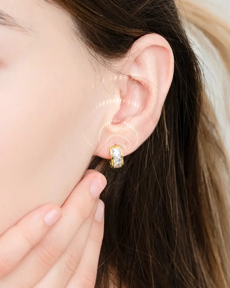 Gold magnetic crystal huggie earring with gold tone and rectangular faceted crystal centerpiece and therapy magnets