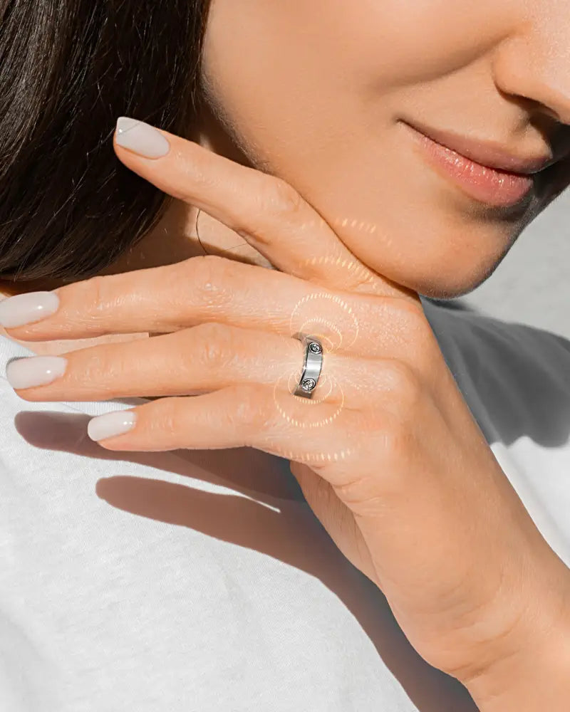 A sleek silver magnetic crystal therapy ring in stainless steel with a modern minimalist design featuring three stones