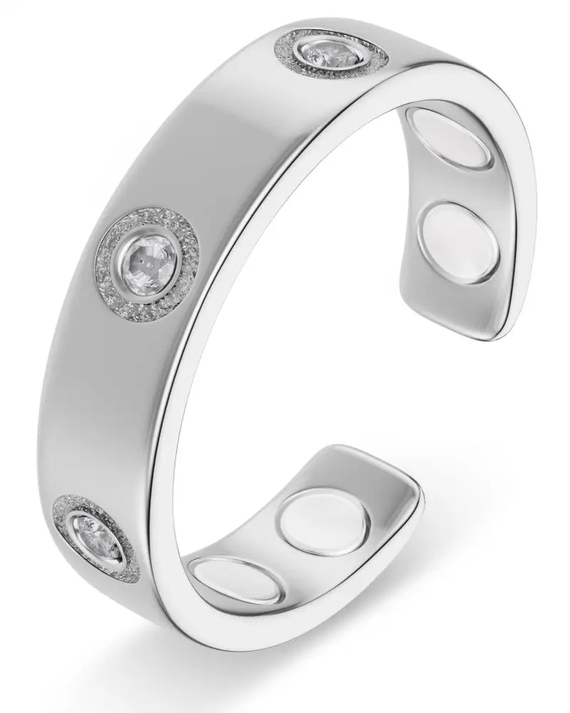 Silver magnetic crystal therapy ring in stainless steel with three round-cut clear stones and accent diamonds in bezel setting