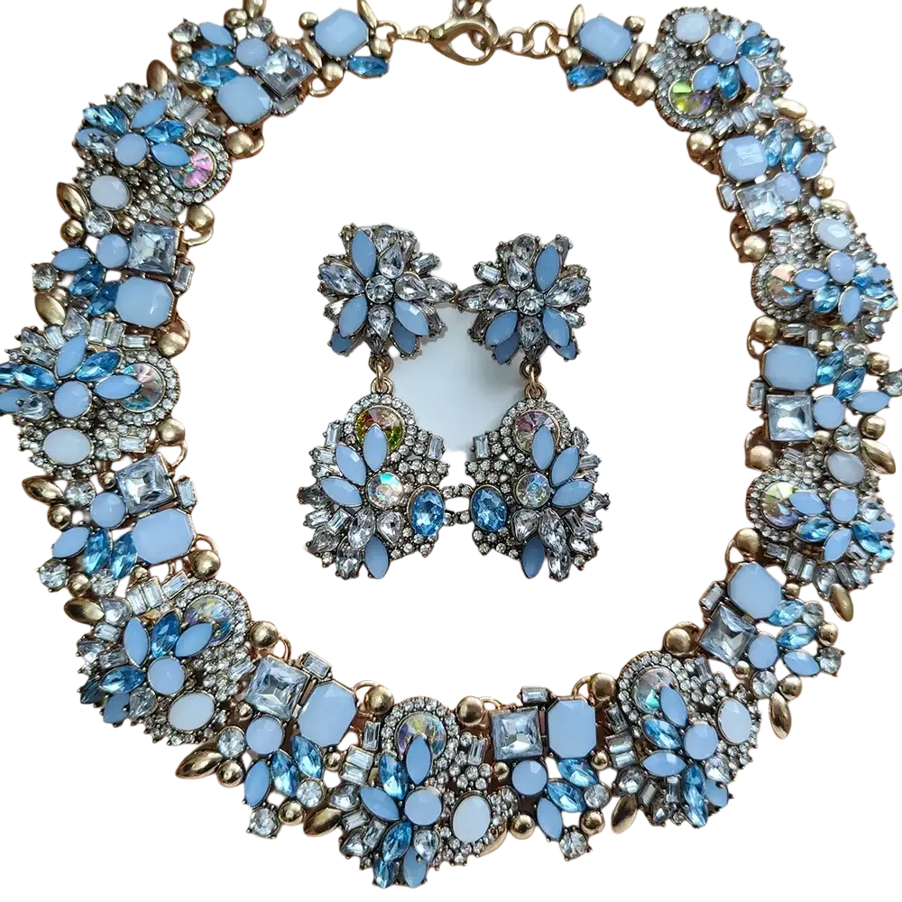 A glamorous blue and gold crystal rhinestone statement necklace set with intricate floral designs and iridescent crystals