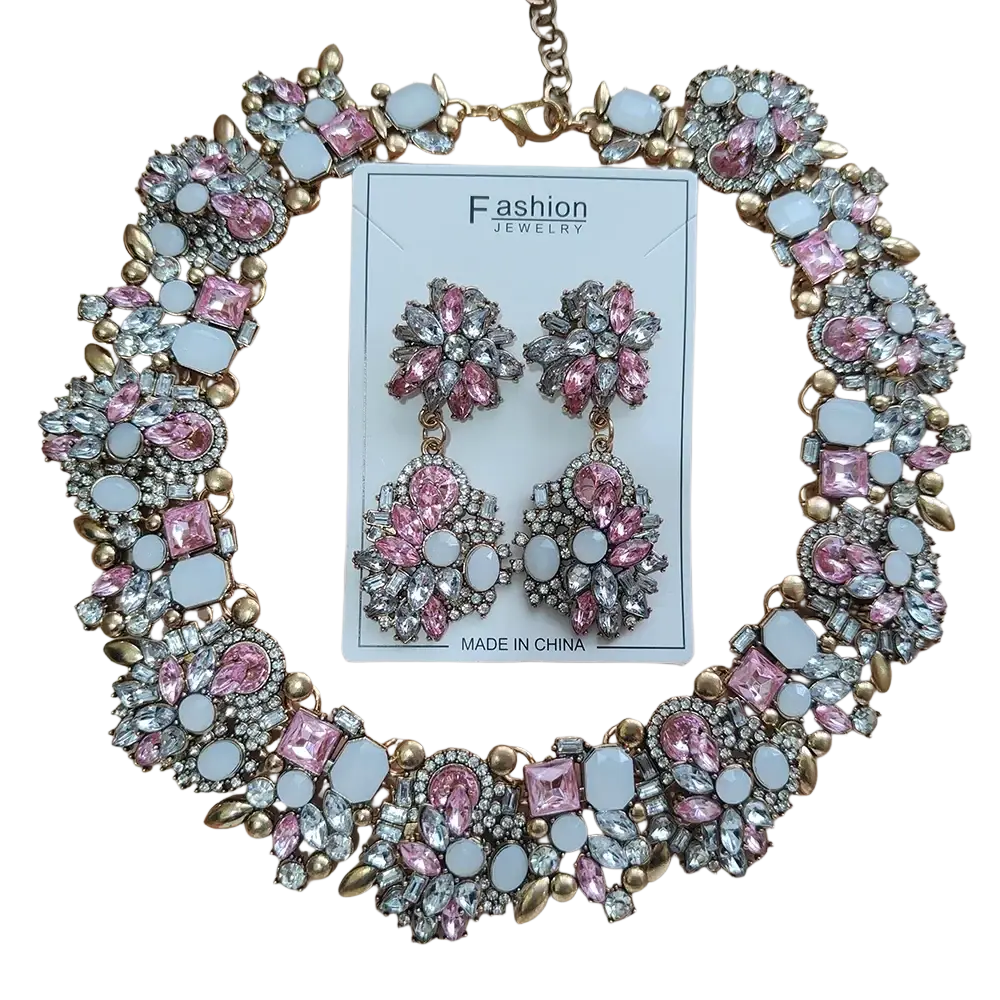 A glamorous pink and silver crystal rhinestone statement necklace set with matching floral earrings in gold-toned metal