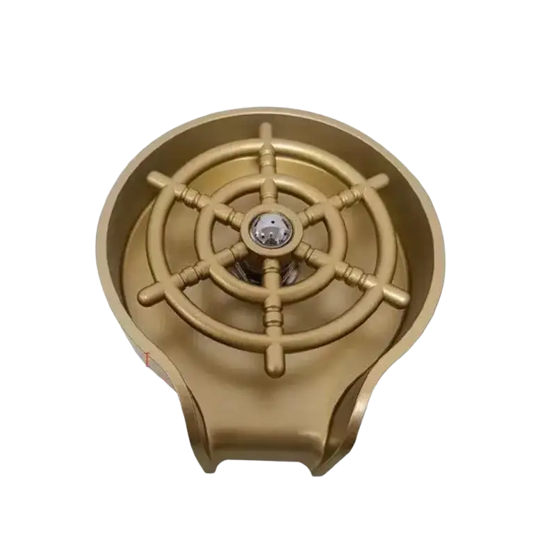 Gold-colored brass finish ship wheel sink drain cover with chrome accent designed for high pressure automatic cup washer