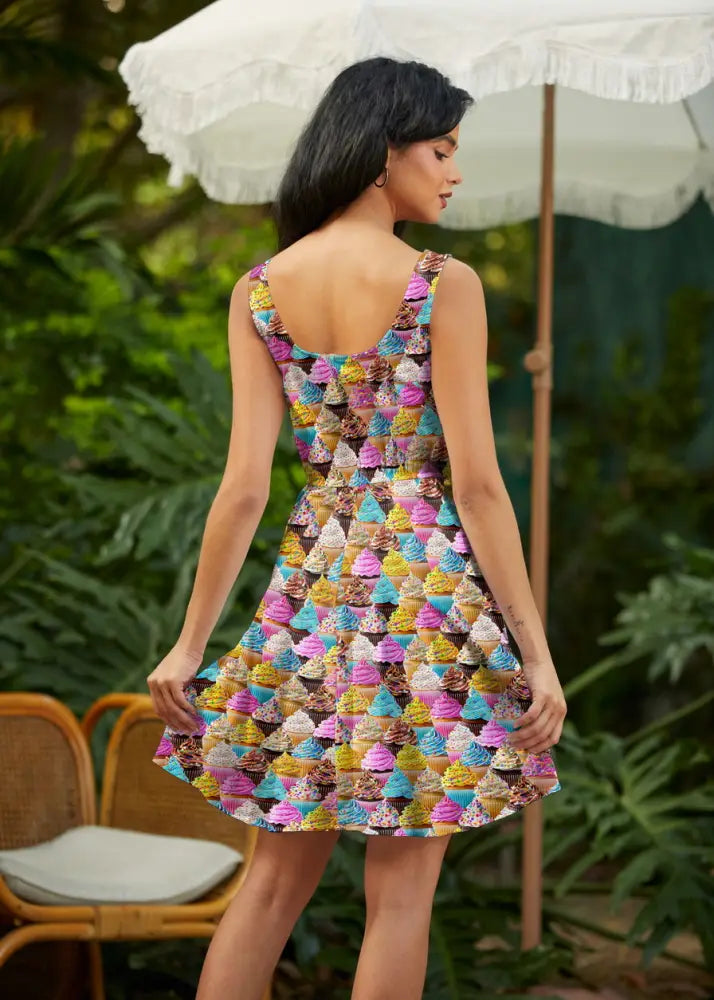 A vibrant sleeveless a-line skater dress with multicolored cupcake print and practical pockets