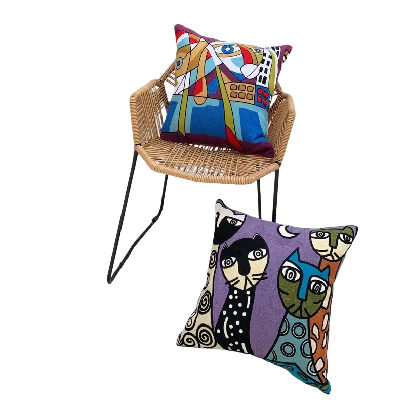 Vibrant embroidered cushion cover 45x45cm with bold colors and abstract animal motifs on wicker chair and ground
