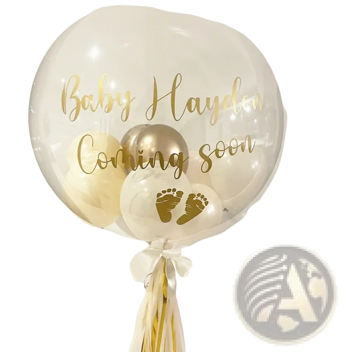 Custom baby shower balloon sticker on clear 36 inch bobo balloon with gold lettering and baby footprints tied with cream balloons