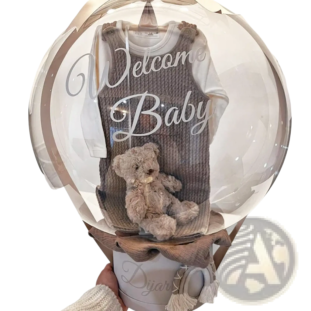 A cozy beige corduroy baby onesie with a white shirt inside a clear balloon gift box for baby shower balloons