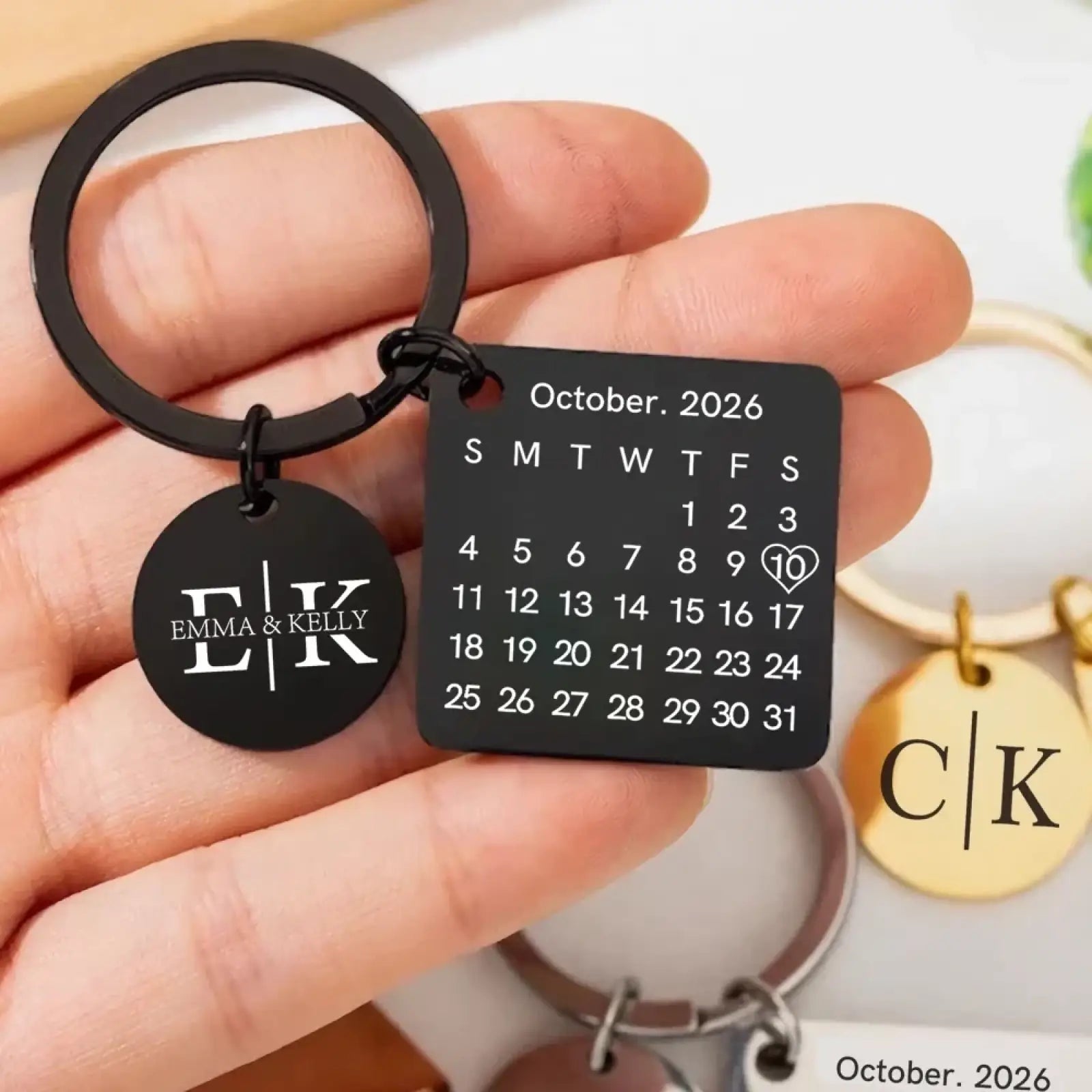 Black stainless steel custom calendar keychain featuring october 2026 square calendar and emma and kelly engraved charm