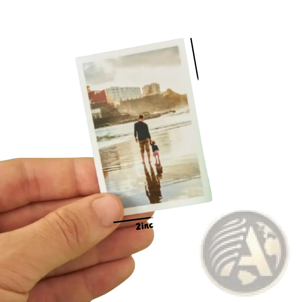 A hand holding a miniature warm nostalgic instant photo print of an adult and child walking on a beach anniversary gift