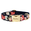 A navy blue floral dog collar with pink and white blossoms and a gold-tone engraved buckle for designer personalized pet accessories