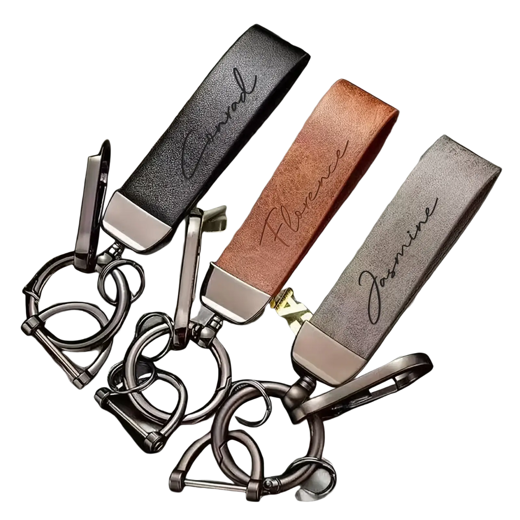 Three personalized brown leather keychains with custom engraved names and silver metallic hardware for gifts