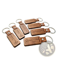Custom engraved wooden leather keychain with silver metal ring featuring personalized names and dates on natural wood