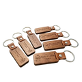Custom engraved wooden leather keychain with silver metal ring featuring personalized names and dates on natural wood