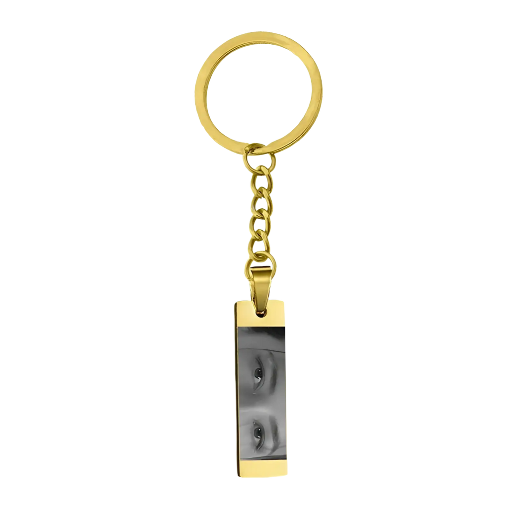 Gold-colored stainless steel rectangular keychain engraved with custom black and white eye photograph