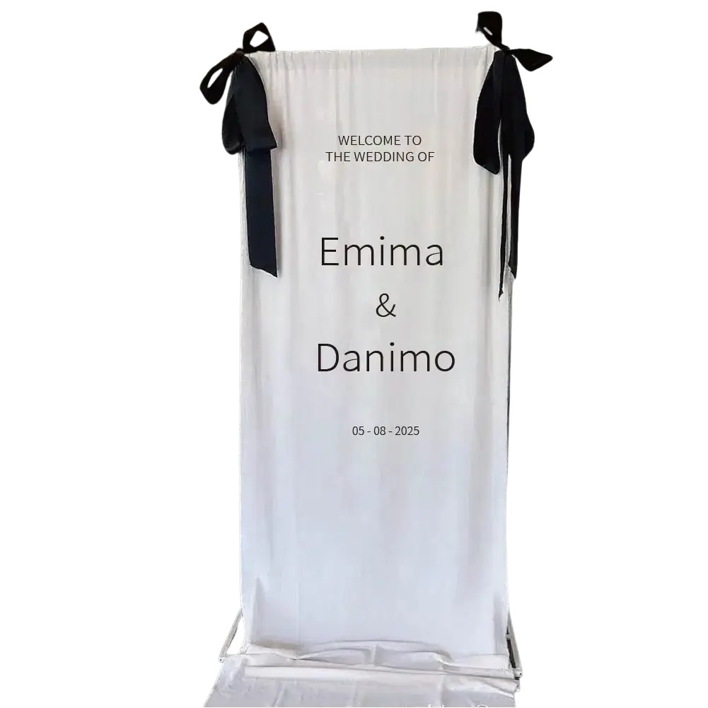 Custom fabric wedding welcome sign featuring white fabric with black ribbons and printed text for wedding decor