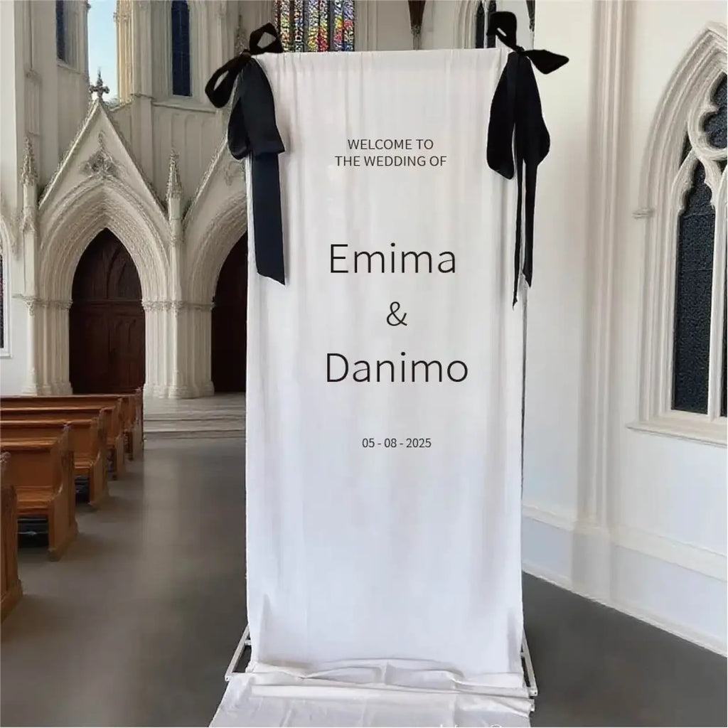 Custom fabric wedding welcome sign featuring white fabric with black ribbons and printed text for wedding decor