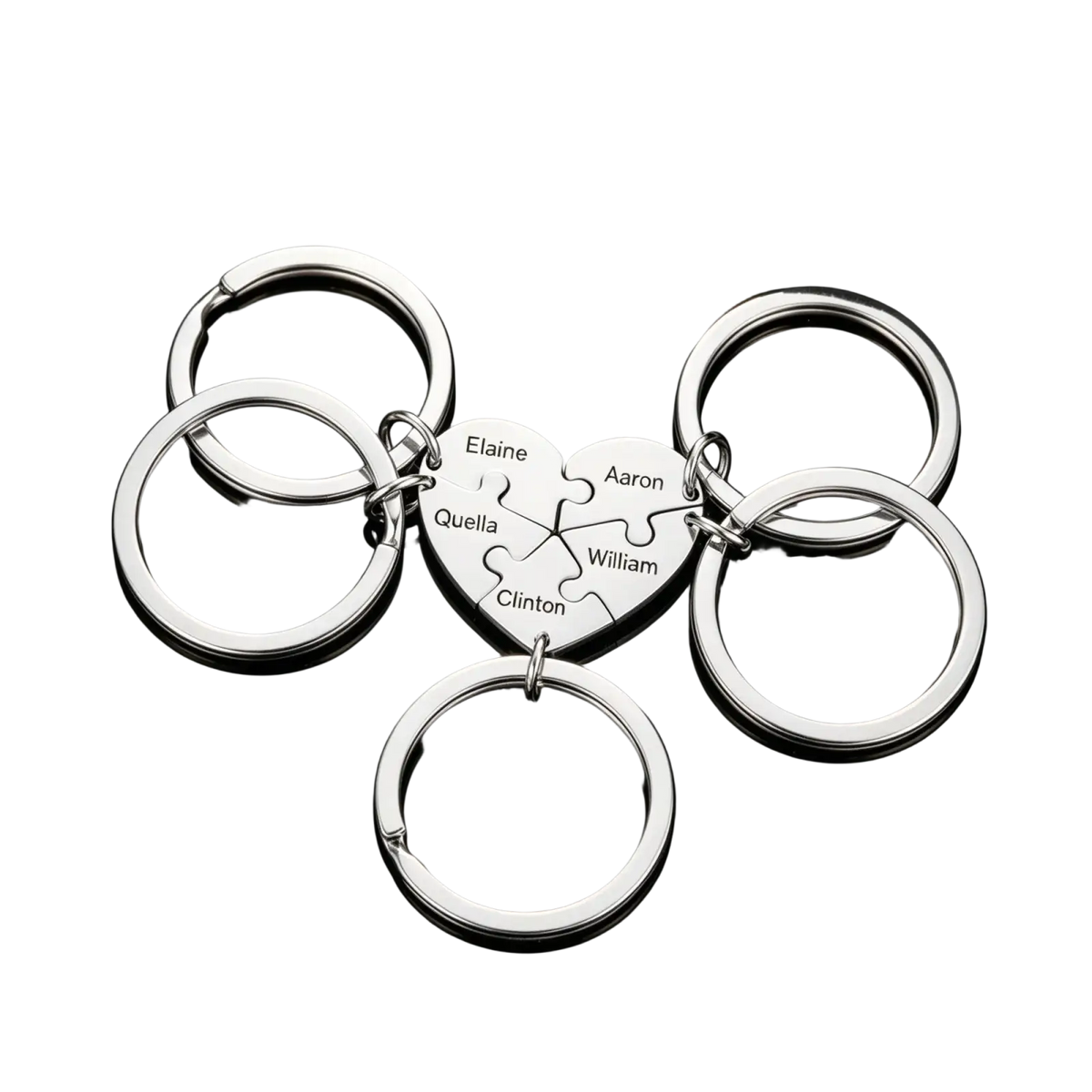 Silver heart-shaped keychain with puzzle-piece design engraved with names elaine aaron quella william and clinton