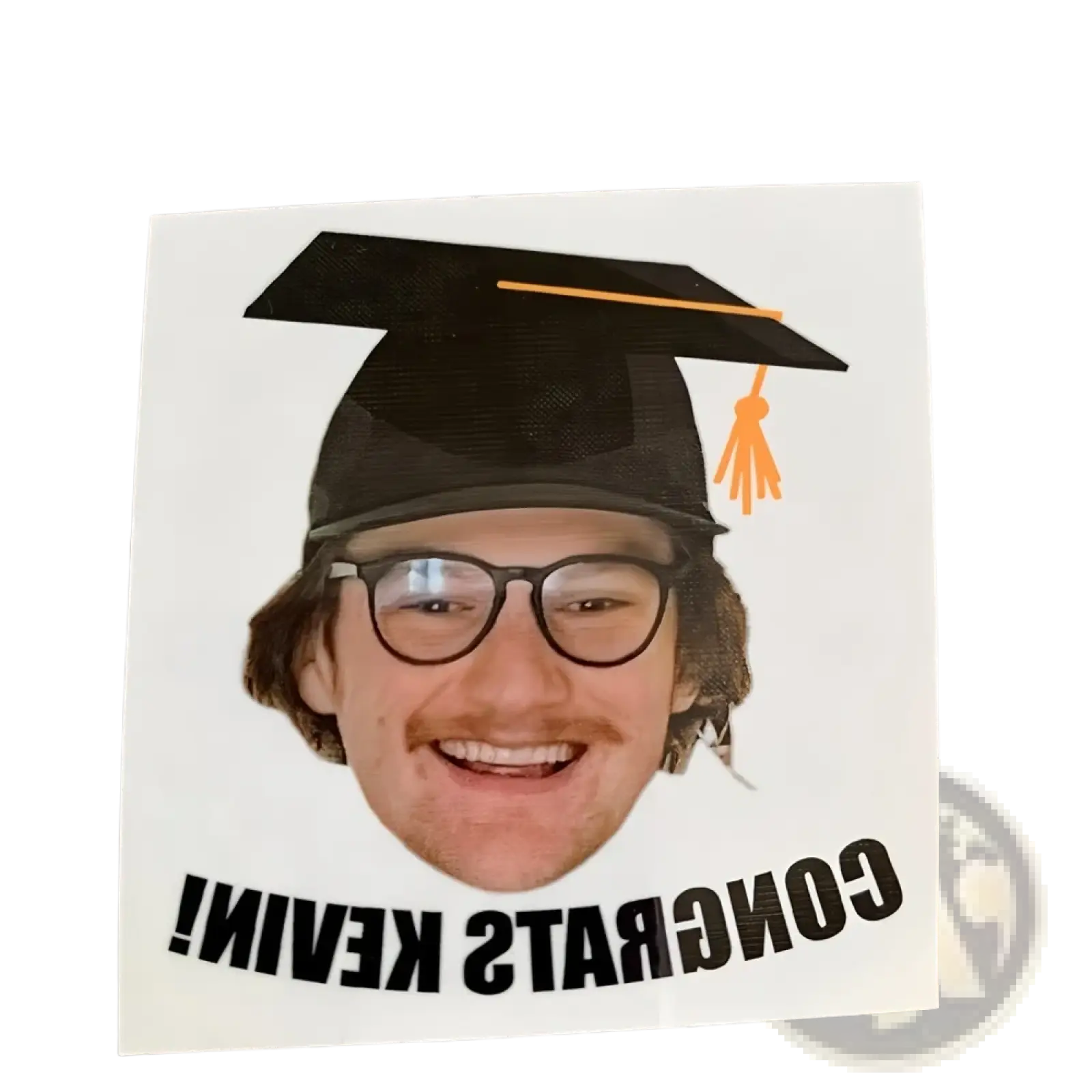 A white custom graduation face tattoo sticker featuring a smiling man with glasses and a black cap with orange tassel