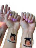 Custom graduation face tattoo featuring a smiling woman in a cap with congrats marcela printed below for party favors