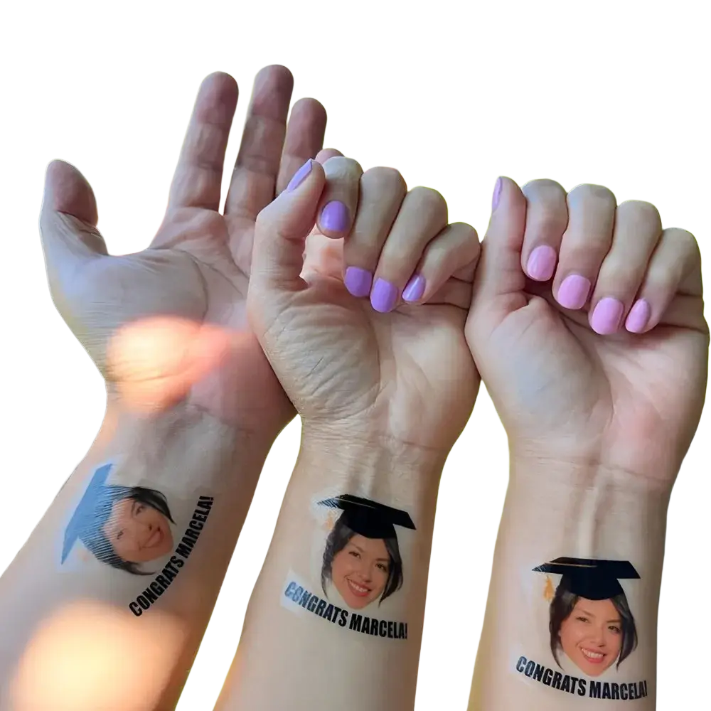 Custom graduation face tattoos featuring a smiling woman with a black mortarboard and congrats marcela text below