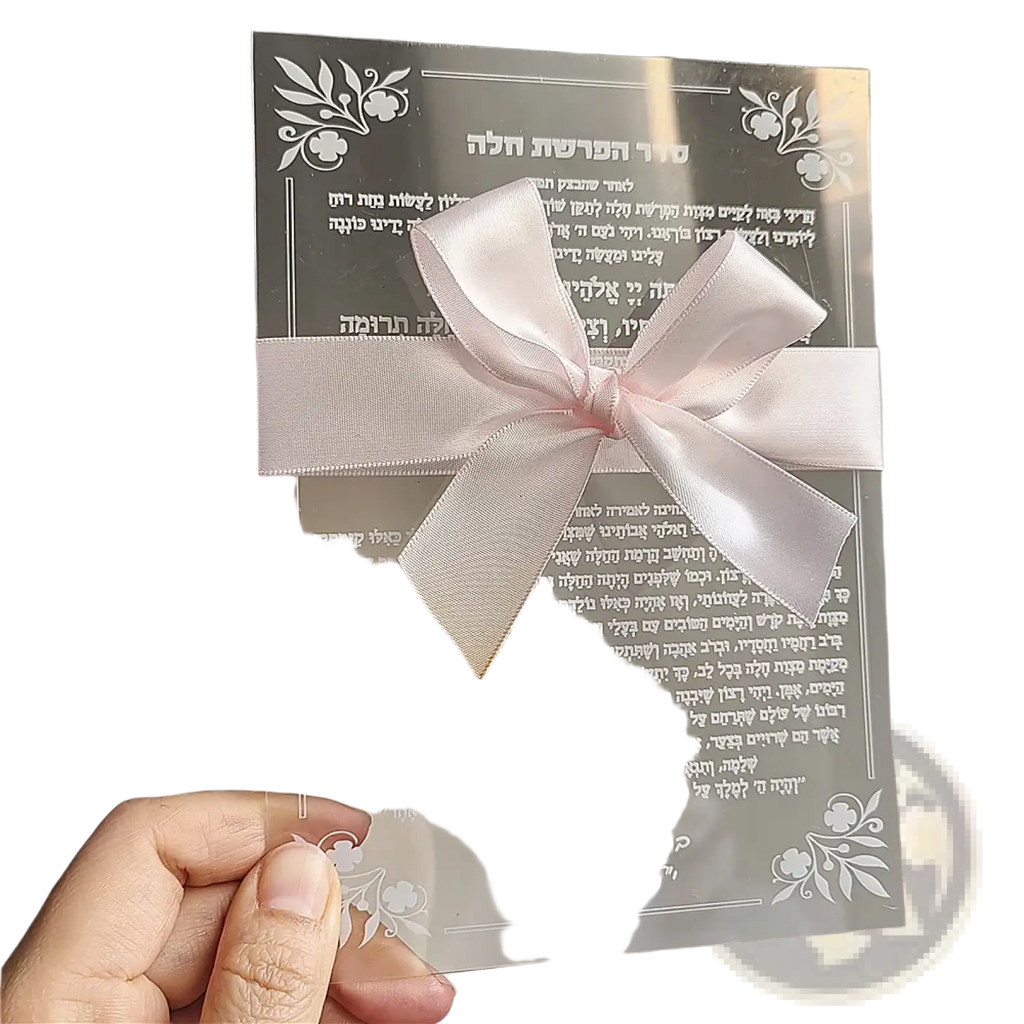 A delicate pink satin bow tied on a transparent acrylic card with engraved hebrew text for wedding and bar mitzvah souvenirs