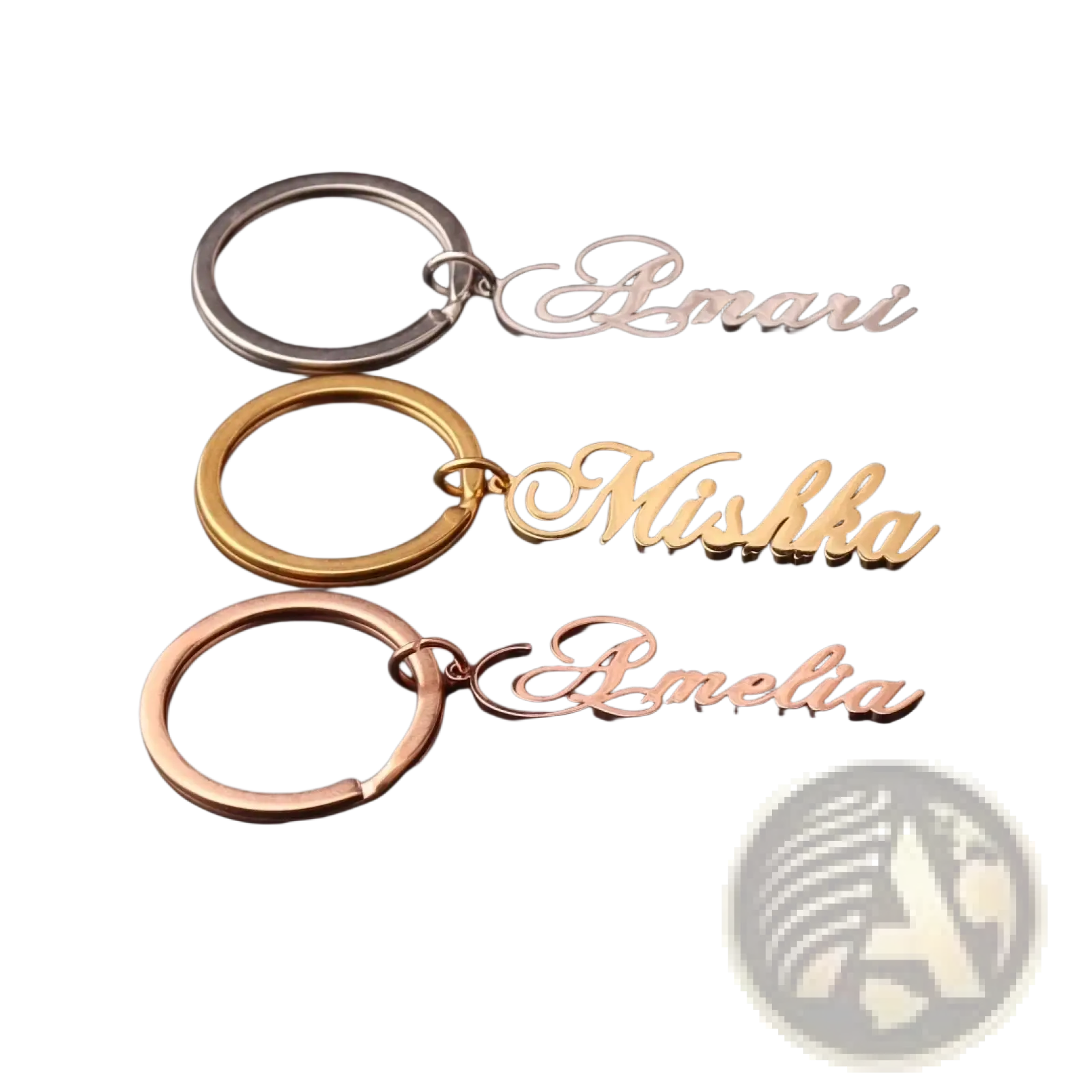 Three custom name keychains in silver gold and rose gold stainless steel with elegant cursive script names amari mishka amelia