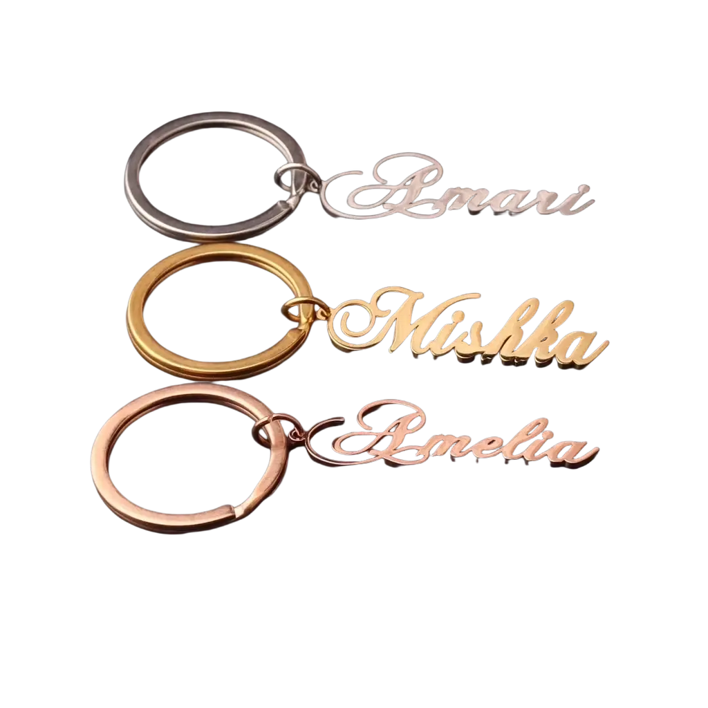 Three custom name keychains in silver gold and rose gold stainless steel with elegant cursive script names amari mishka amelia