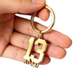 Custom number and name keychain in gold color with number 13 and name Adam engraved in bold blocky font