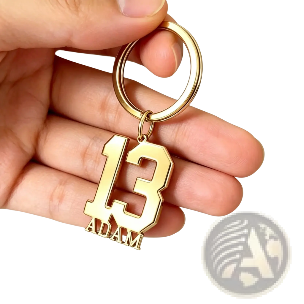 Gold-colored metal custom number and name keychain with bold cut-out 13 and name adam in matching lettering
