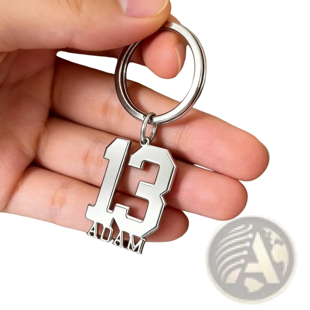 Silver metallic custom number and name keychain with bold cut-out 13 and adam engraved below in athletic font