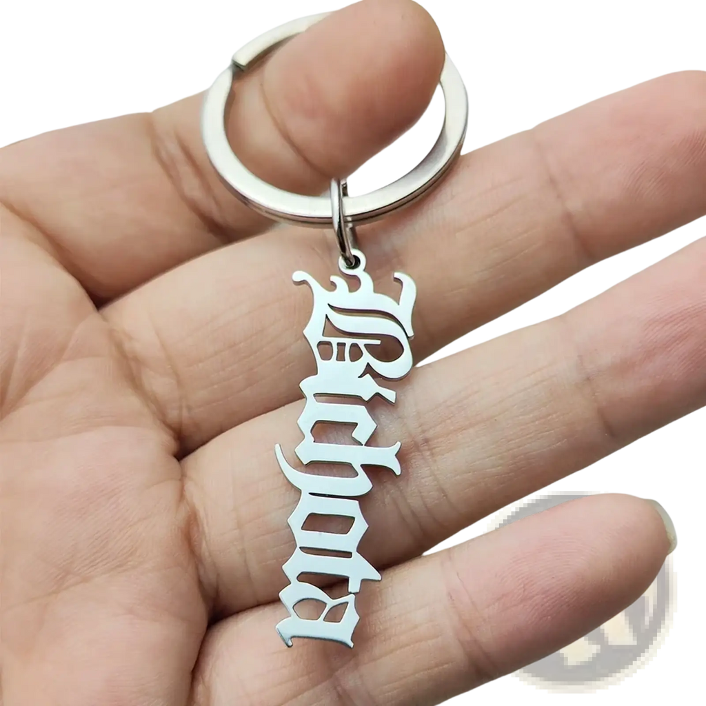 Silver metallic stainless steel keychain with custom ornate vertically stacked gothic-style lettering design