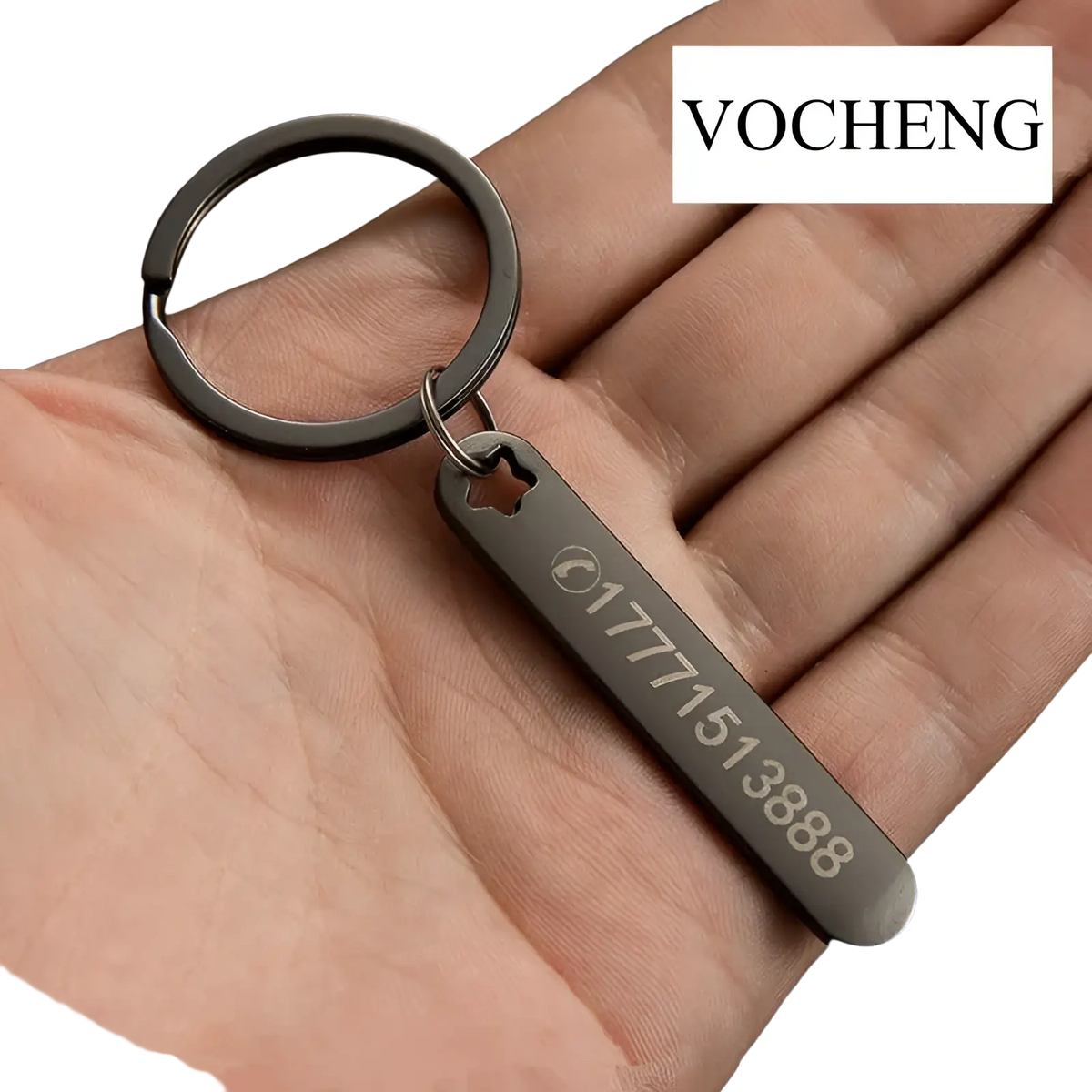 Black metal custom phone number keychain with engraved number and star-shaped cutout laser engraved on metal key ring
