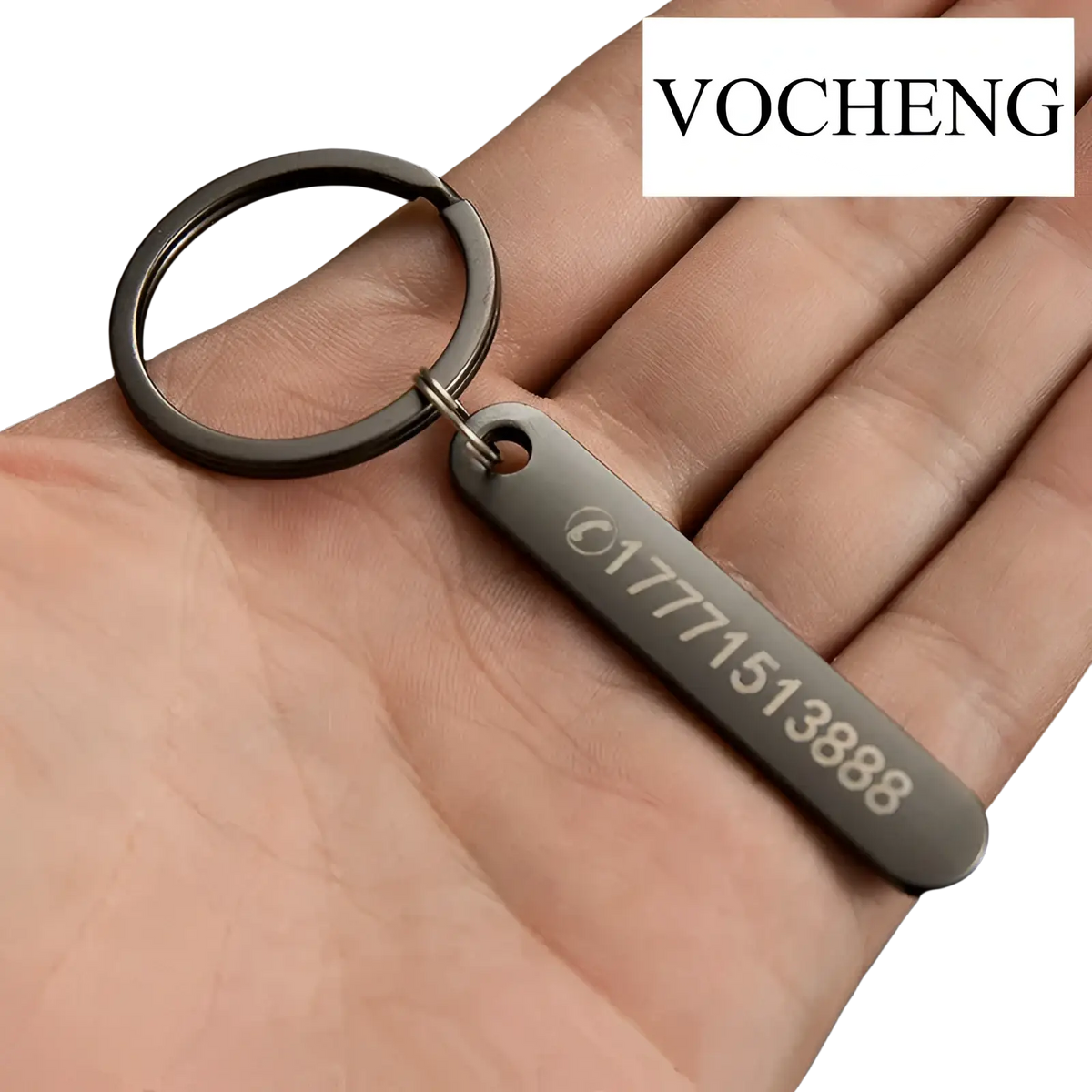 Black metal keychain with rectangular laser engraved tag displaying a phone number and logo for customization