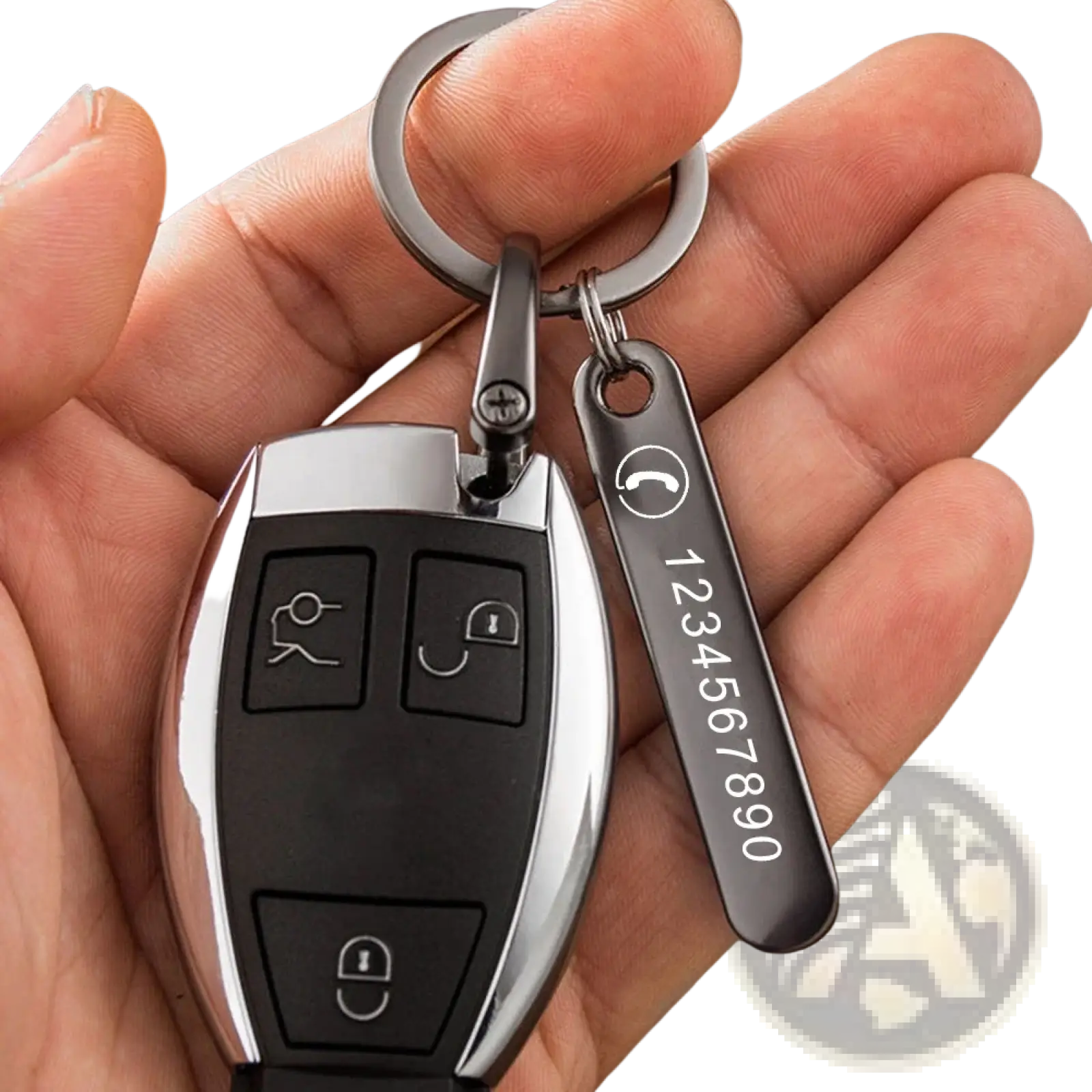 A sleek black and silver car key fob attached to a custom laser engraved metal key ring with phone number tag