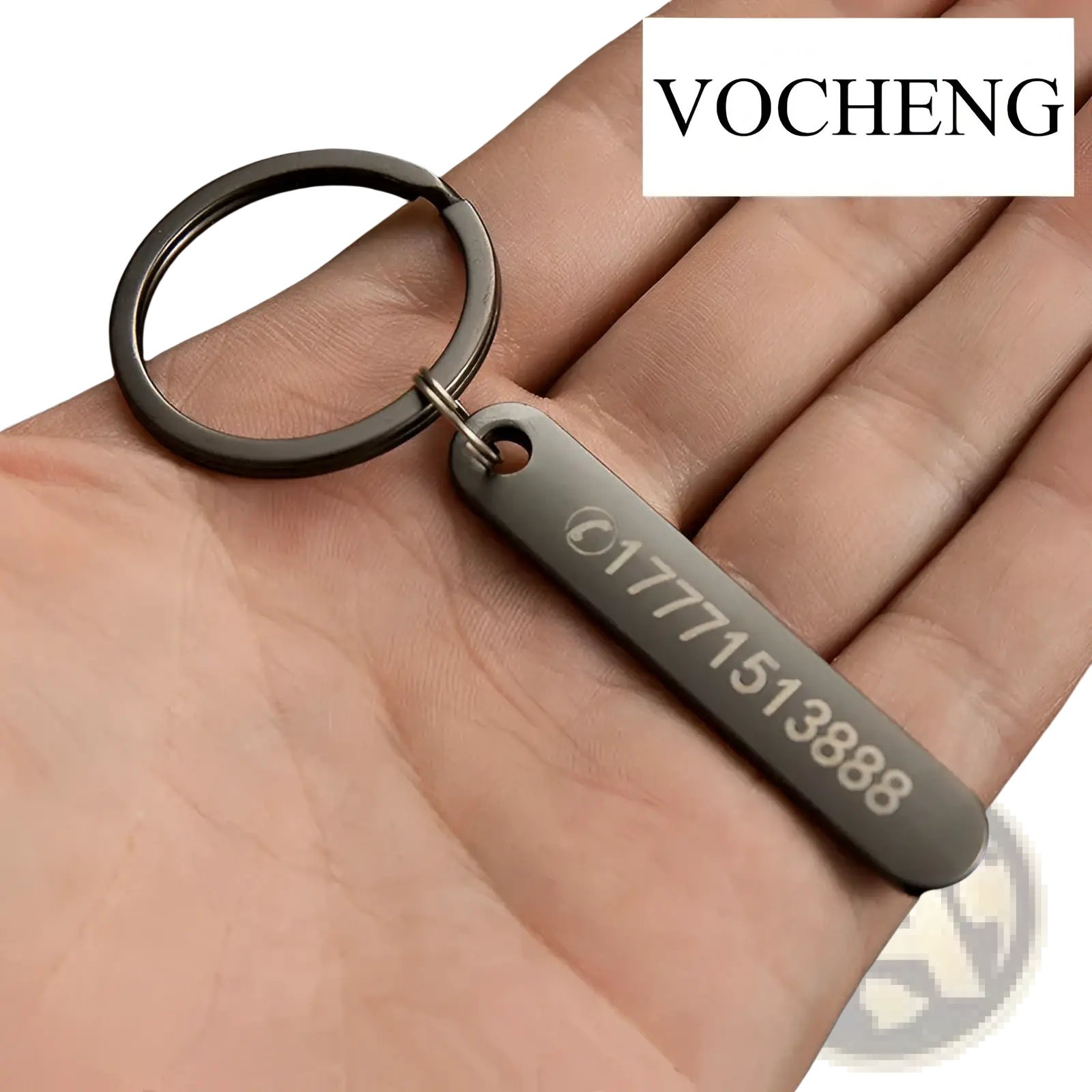 Black metal keychain with rectangular laser engraved tag displaying a phone number and logo for customization