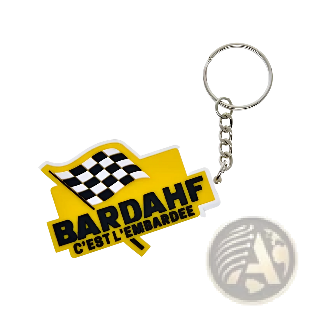 Yellow custom soft pvc keychain featuring black and white checkered flag and bardahf cest lembardee text in bold letters