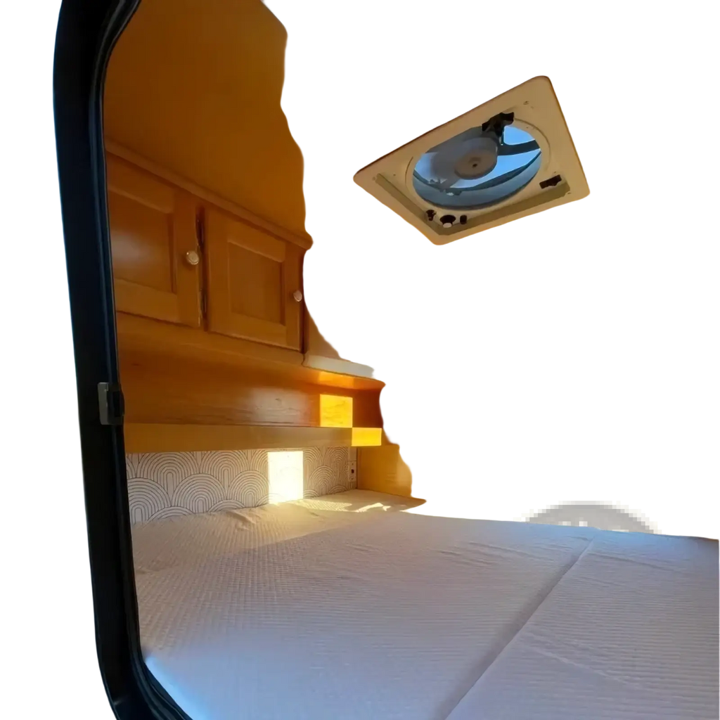Custom teardrop travel trailer warm orange interior with wooden cabinets and white bedding in a compact camper van