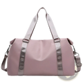 A sleek dusty rose nylon waterproof custom travel duffel bag with silver-toned webbing straps and metal hardware