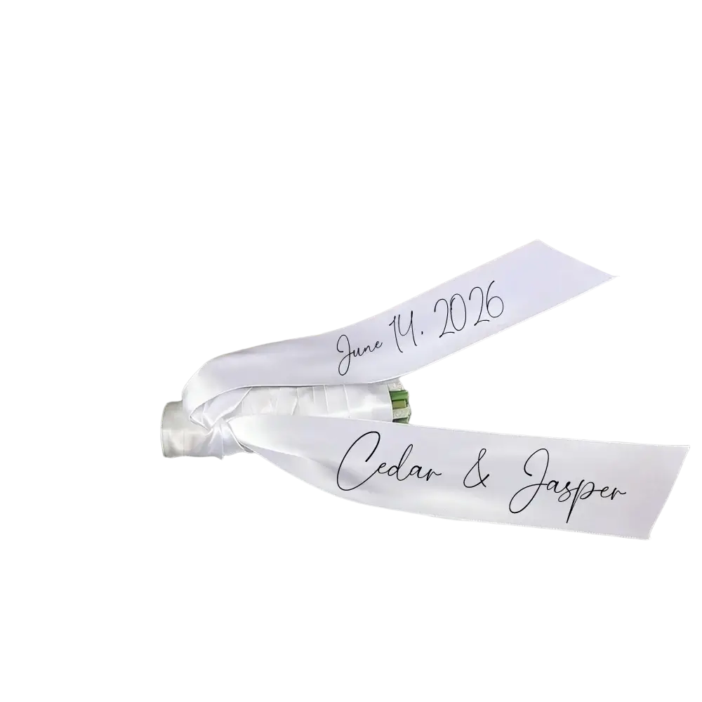 Custom wedding bouquet ribbon in white satin with elegant cursive script displaying personal names and date